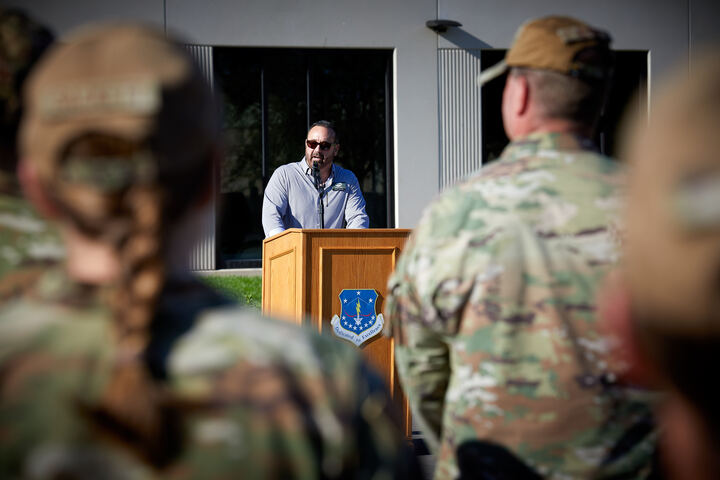 a man standing at a podium with a microphone in front of a group of people