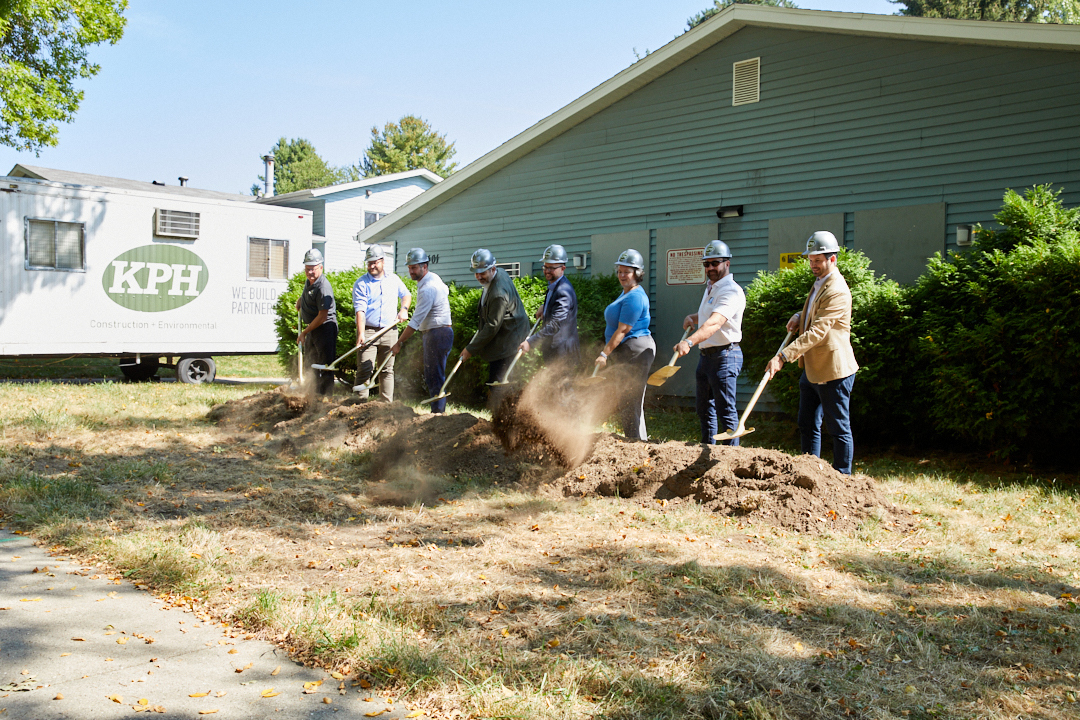 a group of people digging a hole in the ground