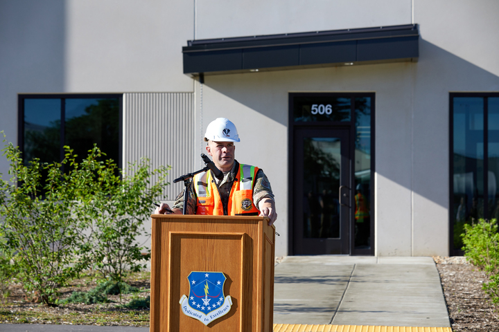 a man in a hard hat standing at a podium