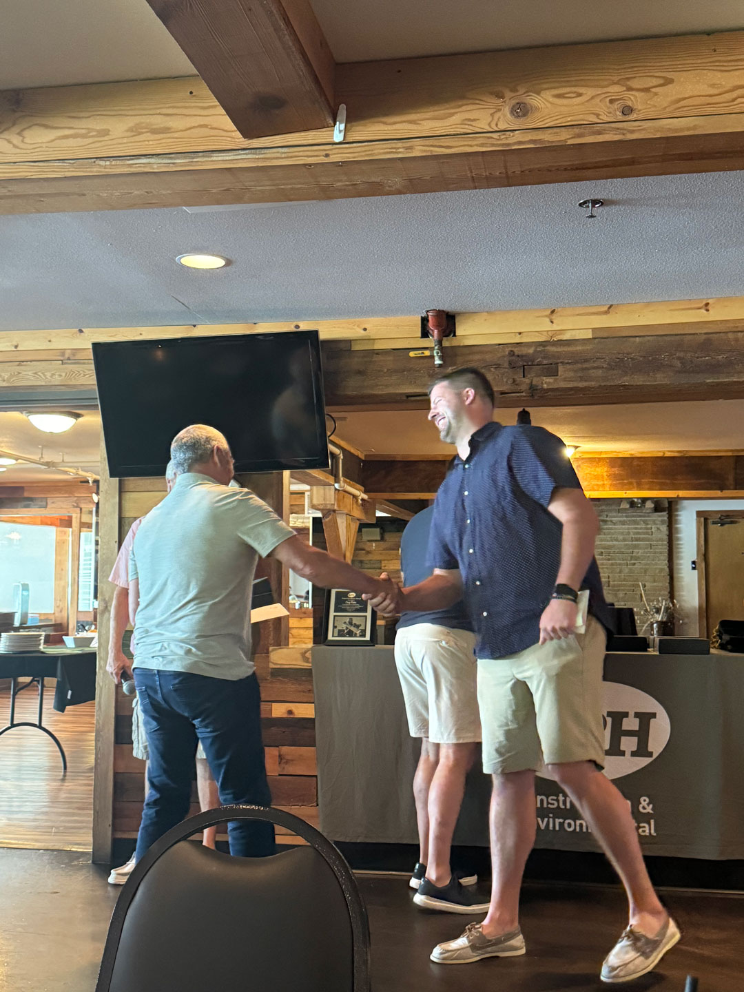 two men shaking hands in a room