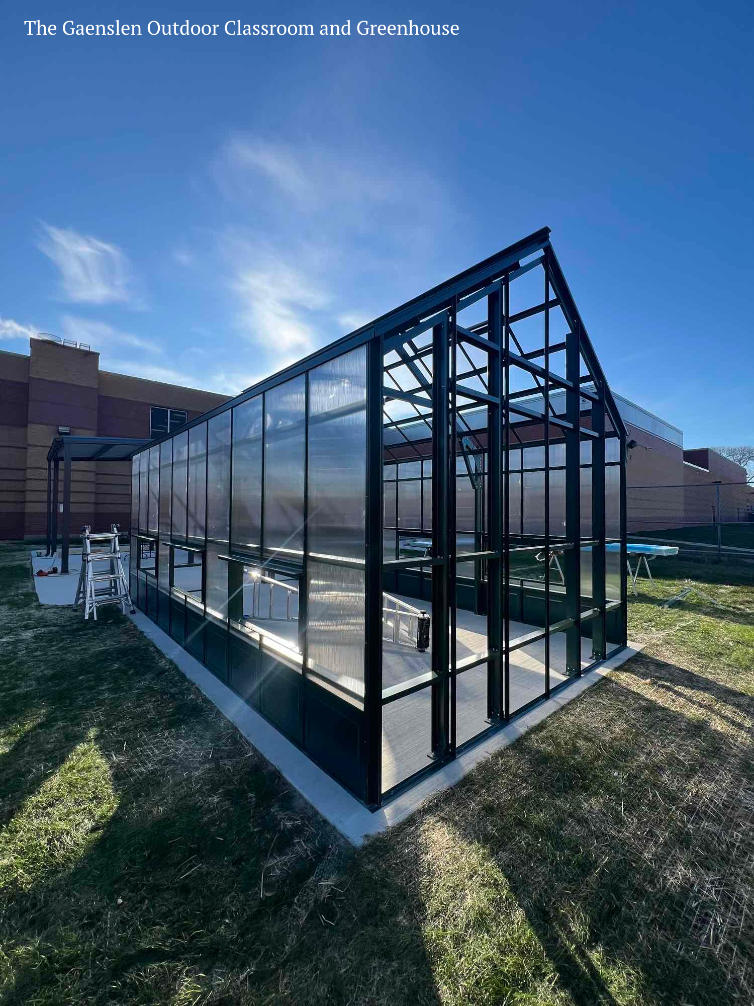 a glass building with a building in the background